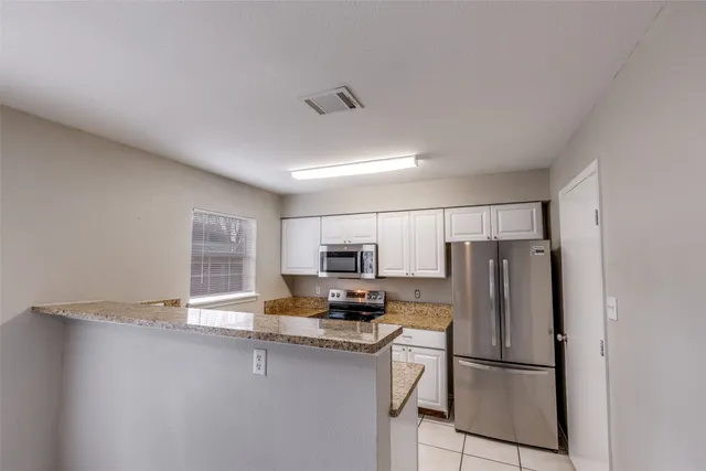 a kitchen with stainless steel appliances granite countertop a refrigerator stove a sink dishwasher and a refrigerator