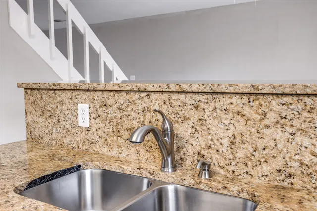 a kitchen with granite countertop a sink and a stove top oven