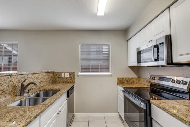 a kitchen with stainless steel appliances granite countertop a stove microwave and refrigerator