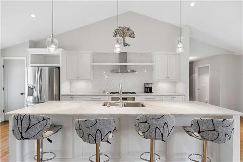 a kitchen with stainless steel appliances granite countertop a sink a center island and cabinets