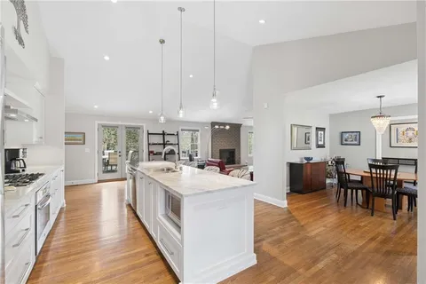a large kitchen with stainless steel appliances granite countertop a lot of counter space and a wooden floors