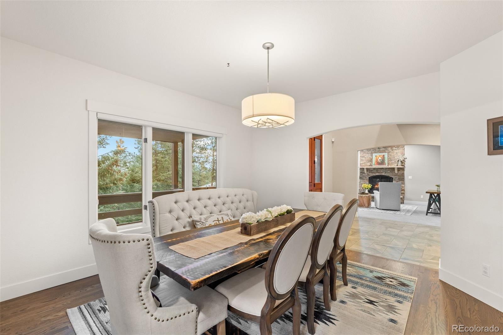 1735 Prima Lane Evergreen, CO 80439 - Photo 19 of 50 a dining room with furniture a chandelier and wooden floor