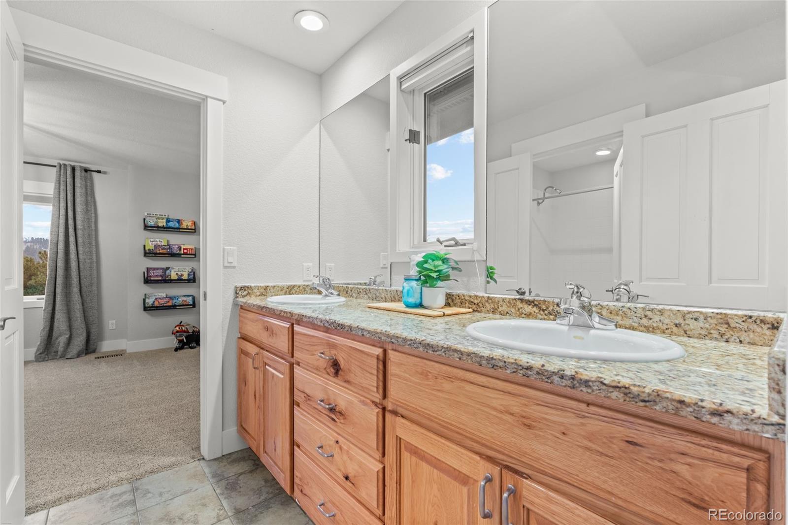 1735 Prima Lane Evergreen, CO 80439 - Photo 33 of 50 a spacious bathroom with a granite countertop sink and a mirror