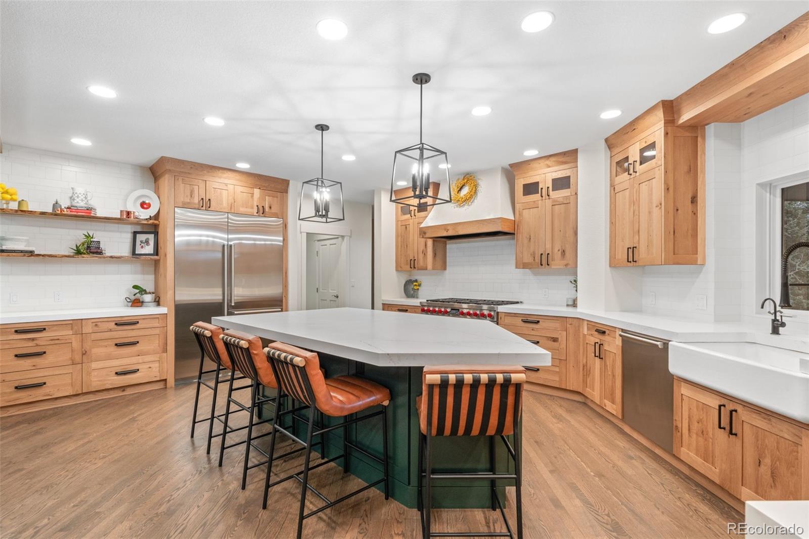 1735 Prima Lane Evergreen, CO 80439 - Photo 9 of 50 a kitchen with stainless steel appliances granite countertop a kitchen island a stove a table and chairs in it