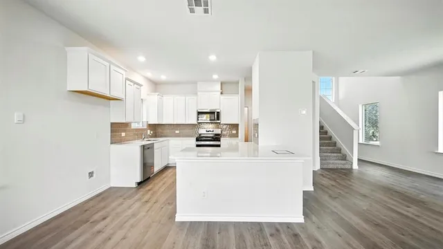 a kitchen with a sink stove top oven and cabinets