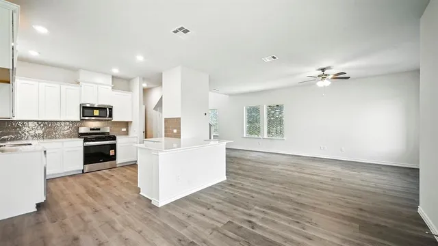 a kitchen with stainless steel appliances granite countertop a stove a sink and a microwave