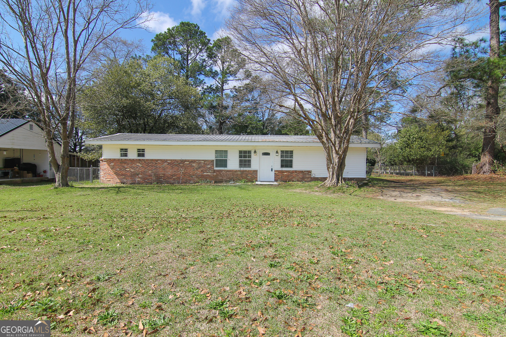 a view of a house with backyard and trees