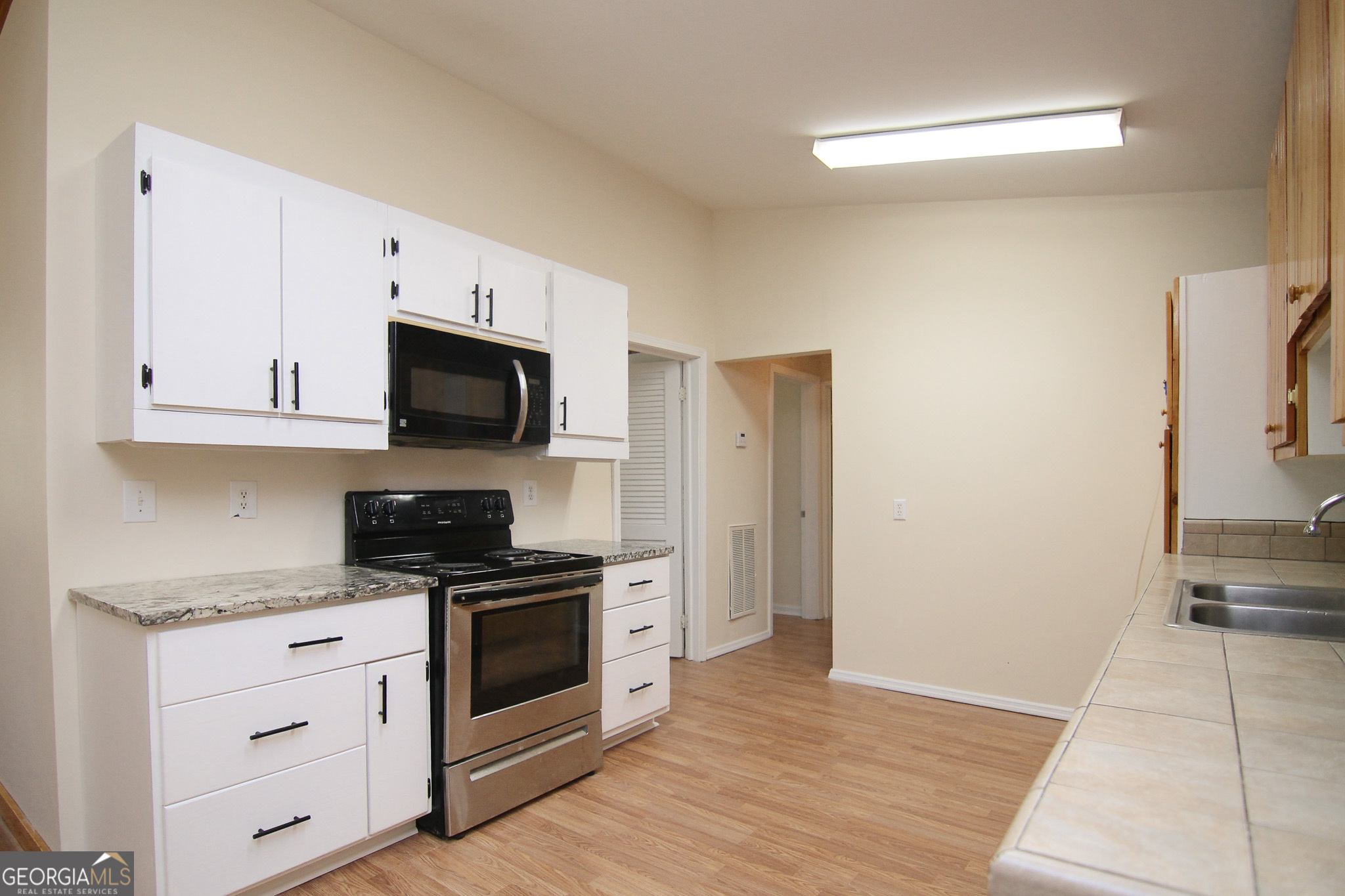 48 Forest Avenue Butler, GA 31006 - Photo 7 of 21 a kitchen with granite countertop white cabinets and stainless steel appliances