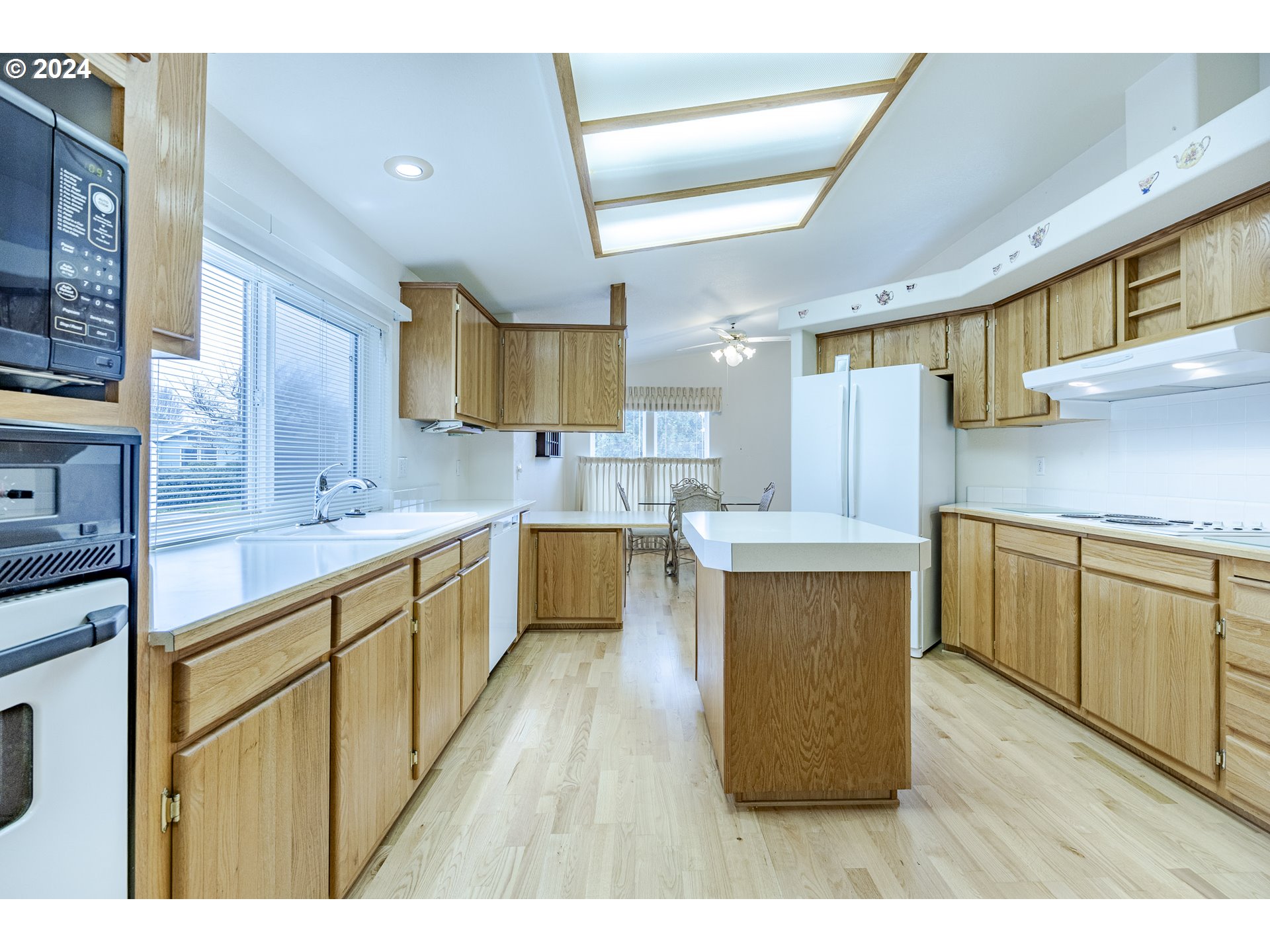 3220 Crescent Avenue, Unit 67 Eugene, OR 97408 - Photo 28 of 48 a large kitchen with cabinets wooden floor and stainless steel appliances
