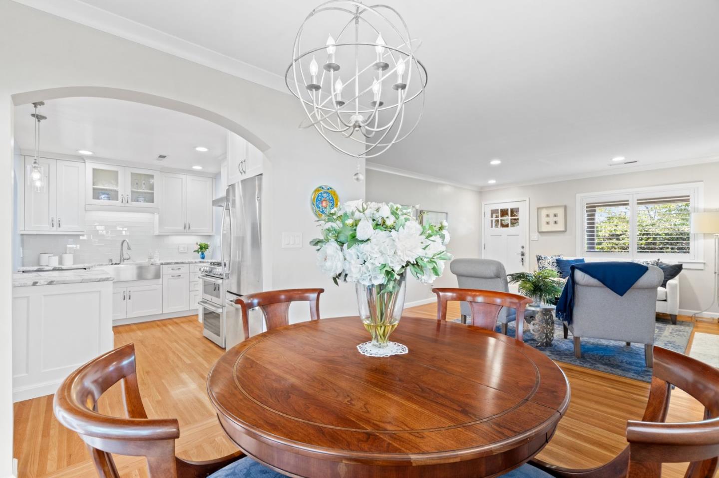 2428 Tulip Road San Jose, CA 95128 - Photo 33 of 59 a dining room with wooden floor a chandelier a glass table and chairs