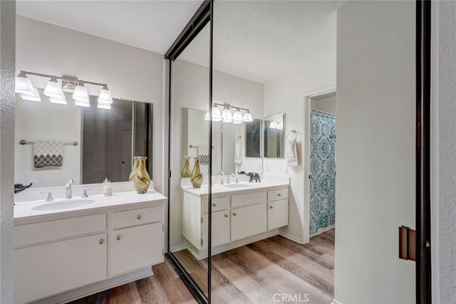 a bathroom with a double vanity sink and mirror with shower