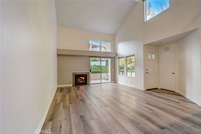 wooden floor fireplace and windows in an empty room