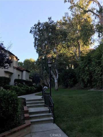 a view of a yard with plants and a large tree
