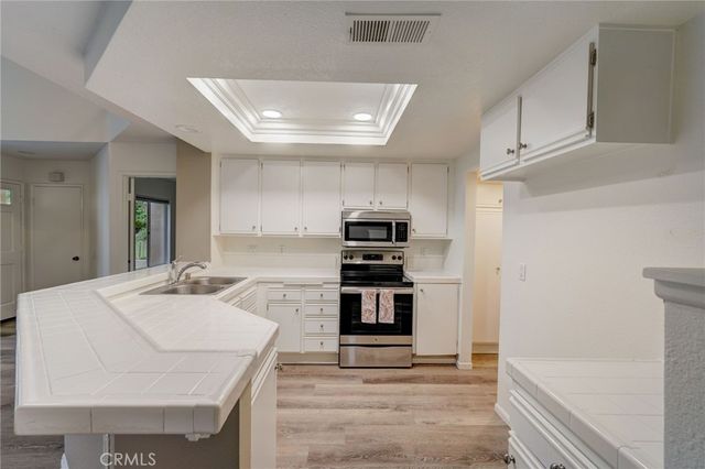 a kitchen with kitchen island a sink stainless steel appliances and cabinets