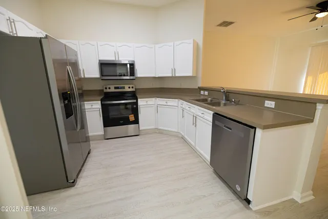 a kitchen with a sink a microwave a refrigerator and cabinets