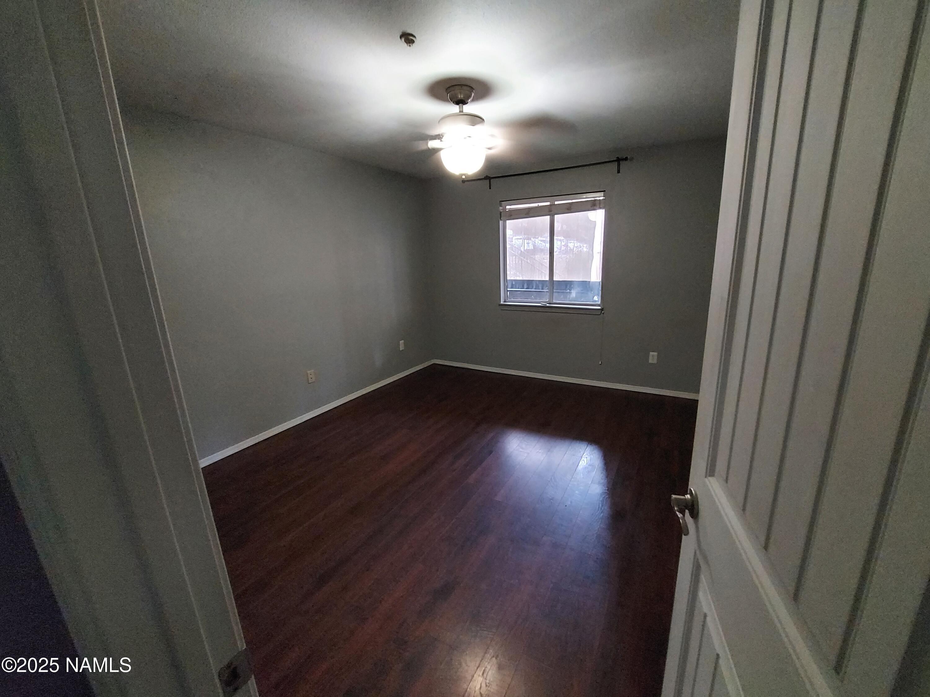1385 West University Avenue, Unit 11181 Flagstaff, AZ 86001 - Photo 2 of 8 an empty room with wooden floor and windows