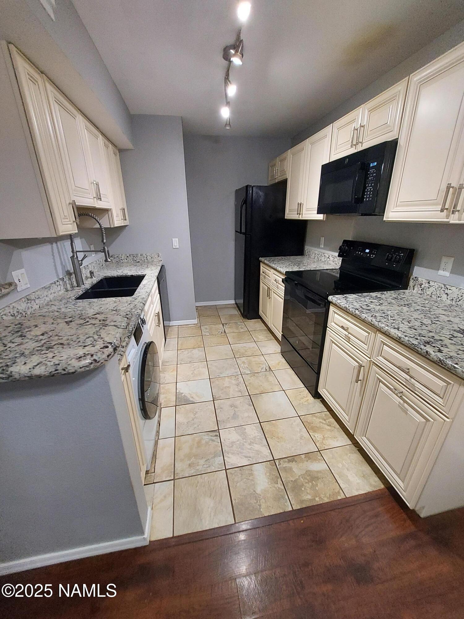 1385 West University Avenue, Unit 11181 Flagstaff, AZ 86001 - Photo 4 of 8 a kitchen with a sink a stove and a refrigerator