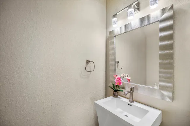 a bathroom with a sink mirror and vanity