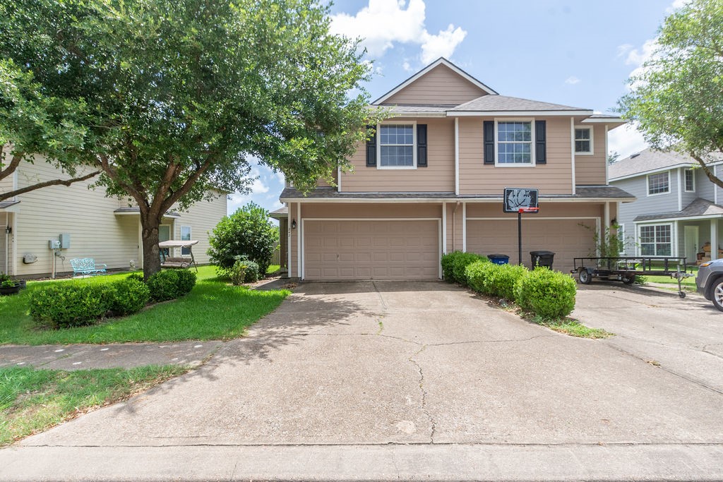 a front view of a house with a yard and a garage