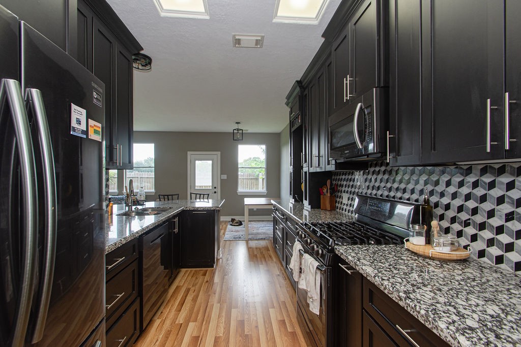 242 Drake Run Lane Dickinson, TX 77539 - Photo 8 of 18 a kitchen with stainless steel appliances granite countertop a refrigerator a stove and a sink