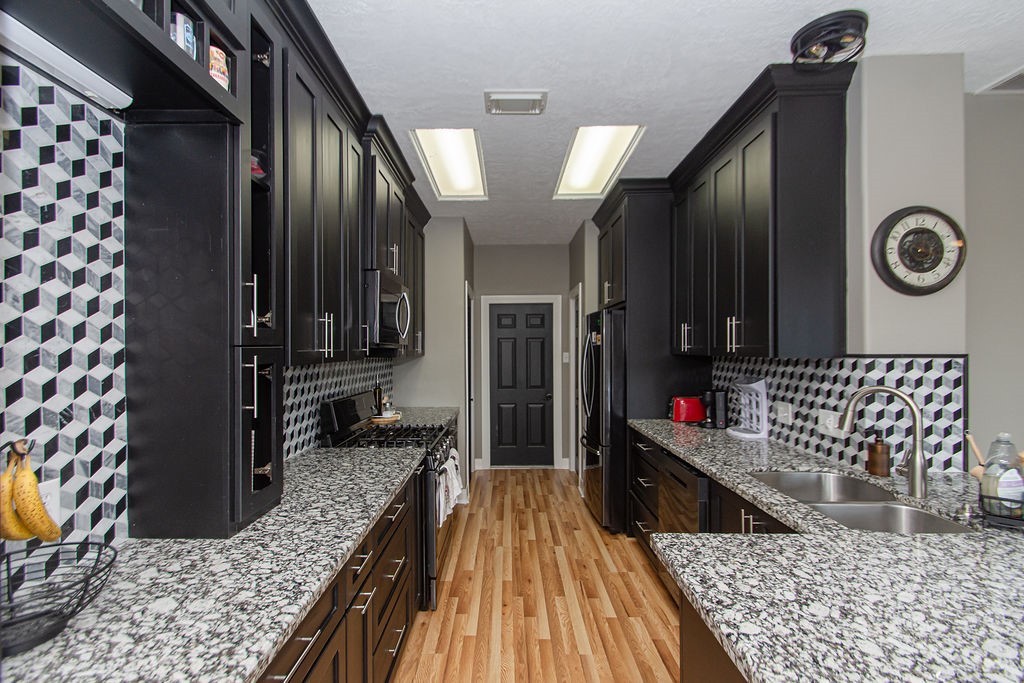 242 Drake Run Lane Dickinson, TX 77539 - Photo 9 of 18 a kitchen with lots of counter top space and wooden floor