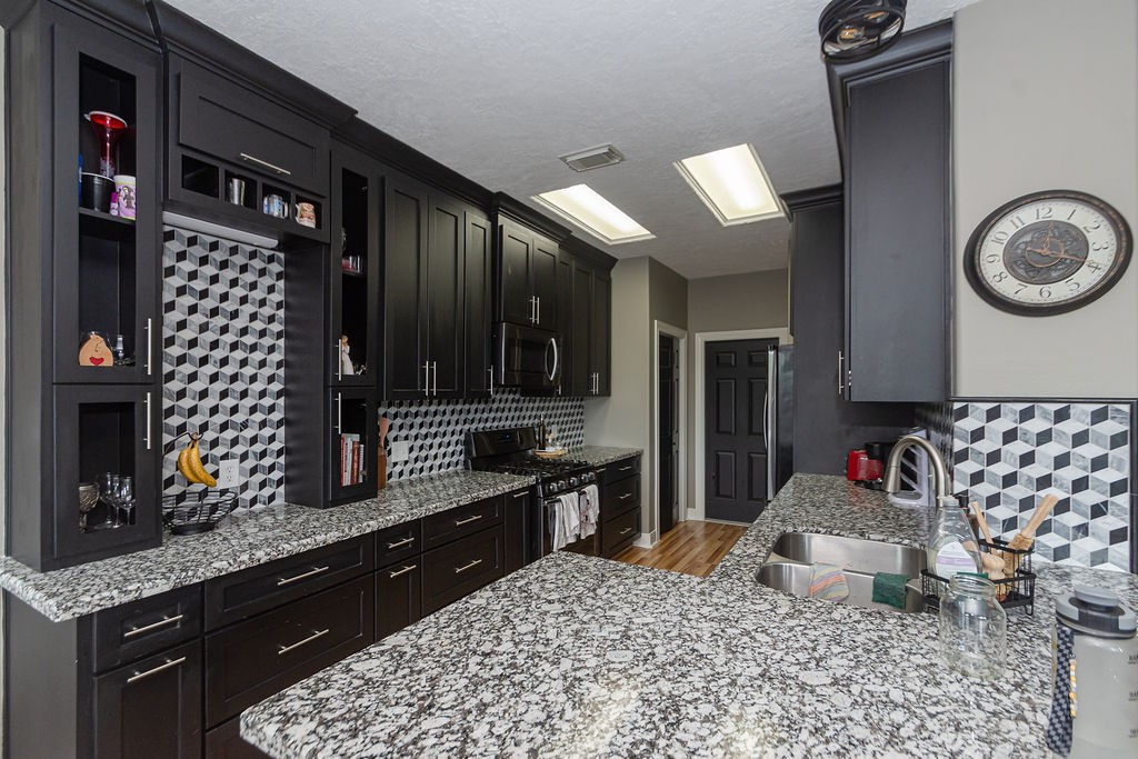 242 Drake Run Lane Dickinson, TX 77539 - Photo 10 of 18 a kitchen with granite countertop lots of clutter and stainless steel appliances