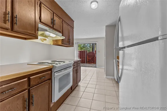 a kitchen with stainless steel appliances granite countertop a refrigerator and a stove