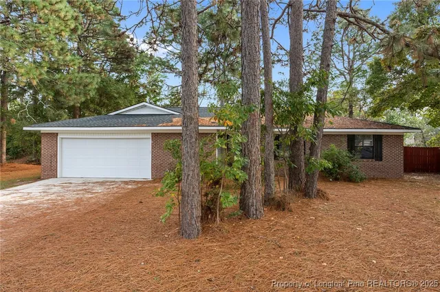 front view of a house with a yard and an trees