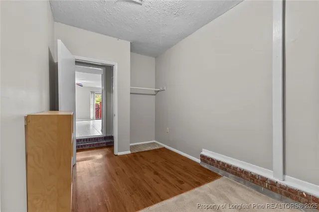 a view of a livingroom with wooden floor and a hallway