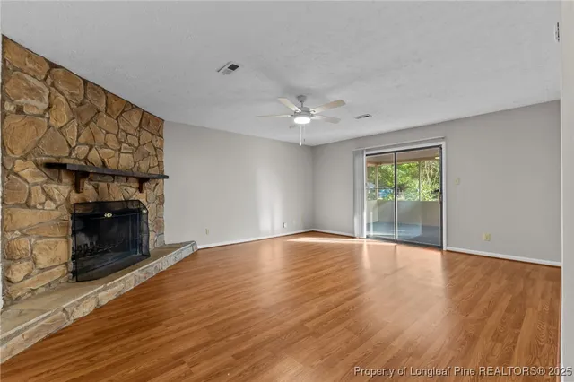 a view of an empty room with a fireplace and a window