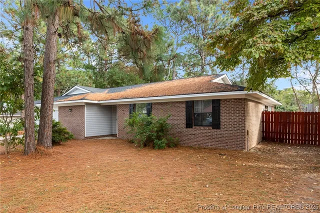 a front view of house with yard and trees around