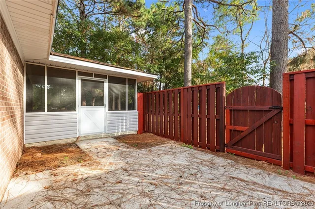 a view of a house with a small yard and wooden fence