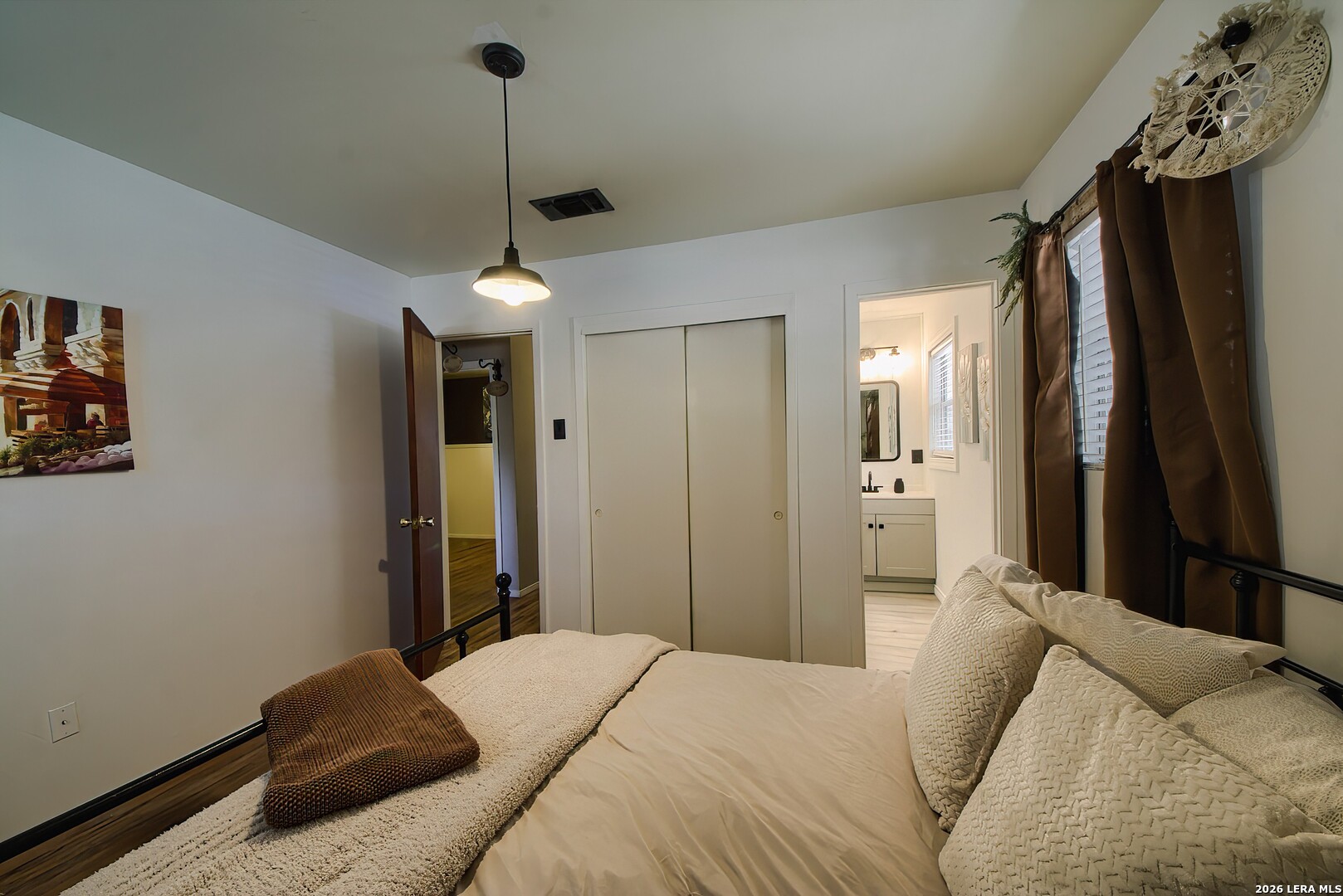 3909 McCall Creek Road Blanco, TX 78606 - Photo 14 of 55 a bedroom with a bed and a chandelier