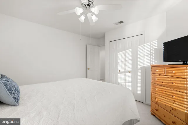 a bedroom with a bed and a flat tv screen on dresser