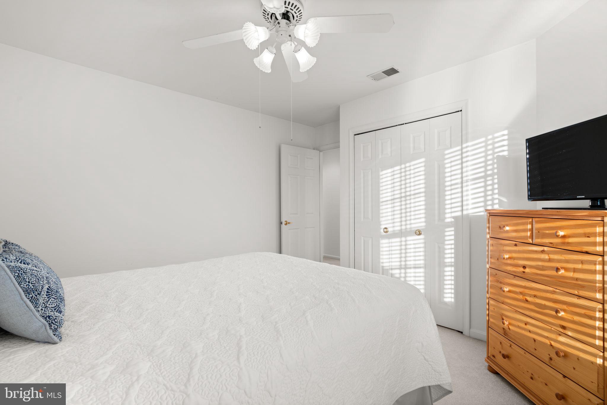 5161 Harpers Farm Road, Unit 27 Columbia, MD 21044 - Photo 28 of 55 a bedroom with a bed and a flat tv screen on dresser