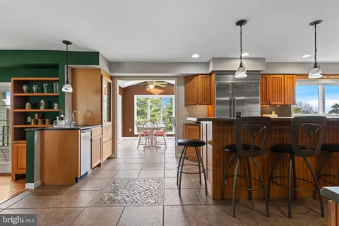 a open kitchen with stainless steel appliances granite countertop a stove top oven a refrigerator and a sink with granite countertops