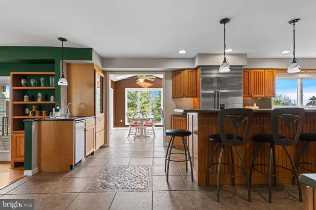 a open kitchen with stainless steel appliances granite countertop a stove top oven a refrigerator and a sink with granite countertops