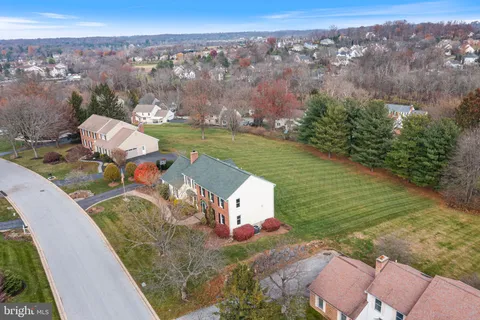 an aerial view of a house with a garden and lake view