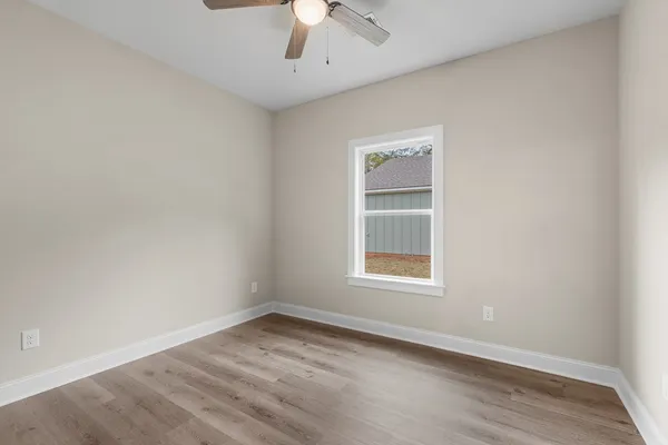 an empty room with a window and a ceiling fan