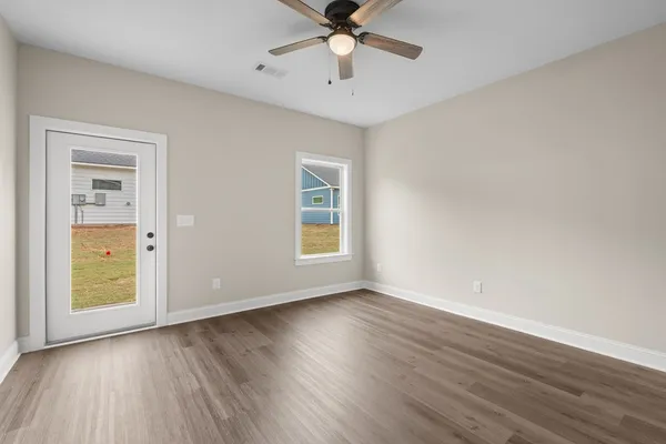an empty room with wooden floor and windows