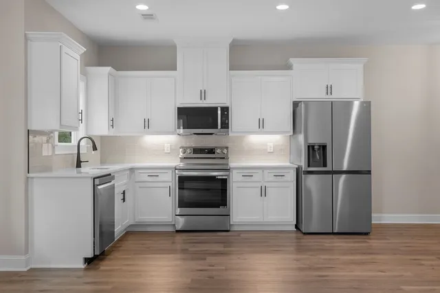 a kitchen with a refrigerator stove and wooden cabinets