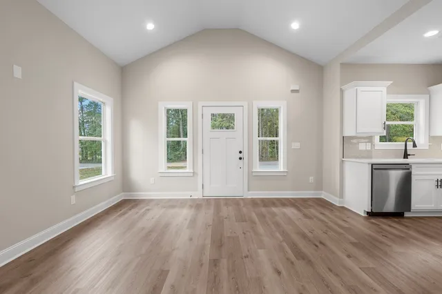 an empty room with wooden floor and windows