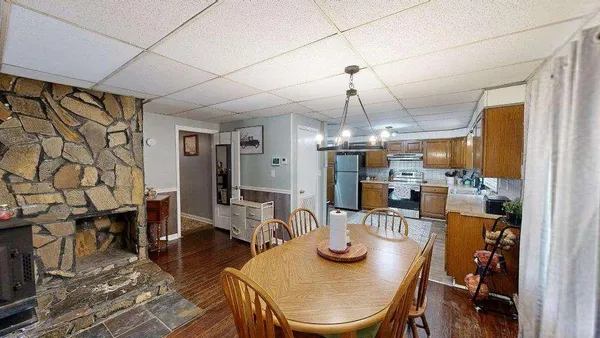 a view of a dining room with furniture a chandelier and wooden floor