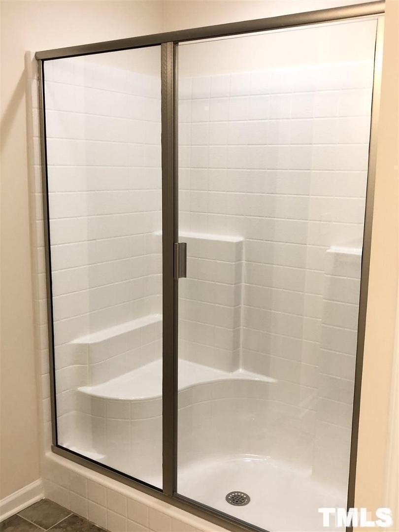 2555 Rambling Creek Road Apex, NC 27523 - Photo 14 of 23 a bathroom with a glass shower door