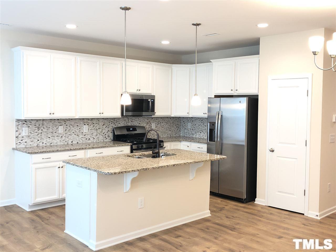 2555 Rambling Creek Road Apex, NC 27523 - Photo 4 of 23 a kitchen with stainless steel appliances granite countertop a refrigerator a sink a stove and a microwave