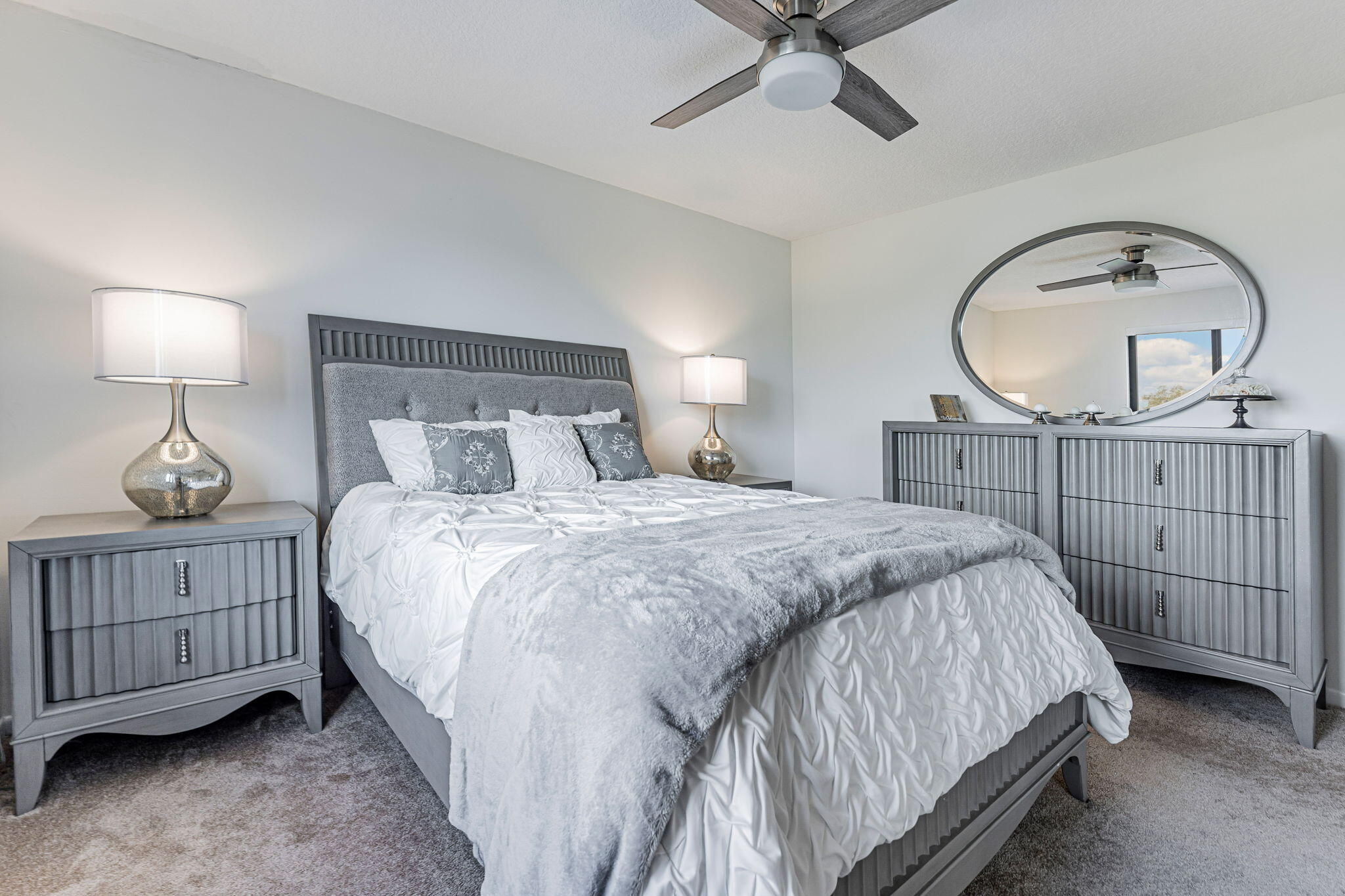 12715 Kingsway Road Wellington, FL 33414 - Photo 12 of 36 a bedroom with a bed a chandelier and dresser