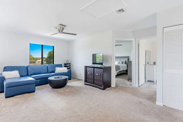 a living room with furniture a window and a ceiling fan