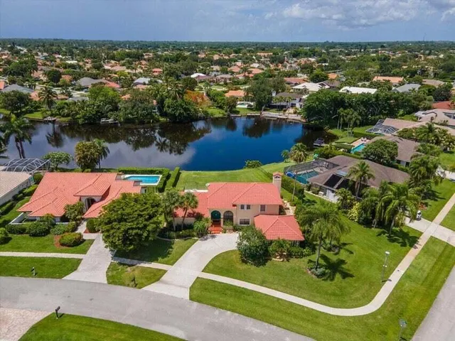 an aerial view of a house with a garden and lake view