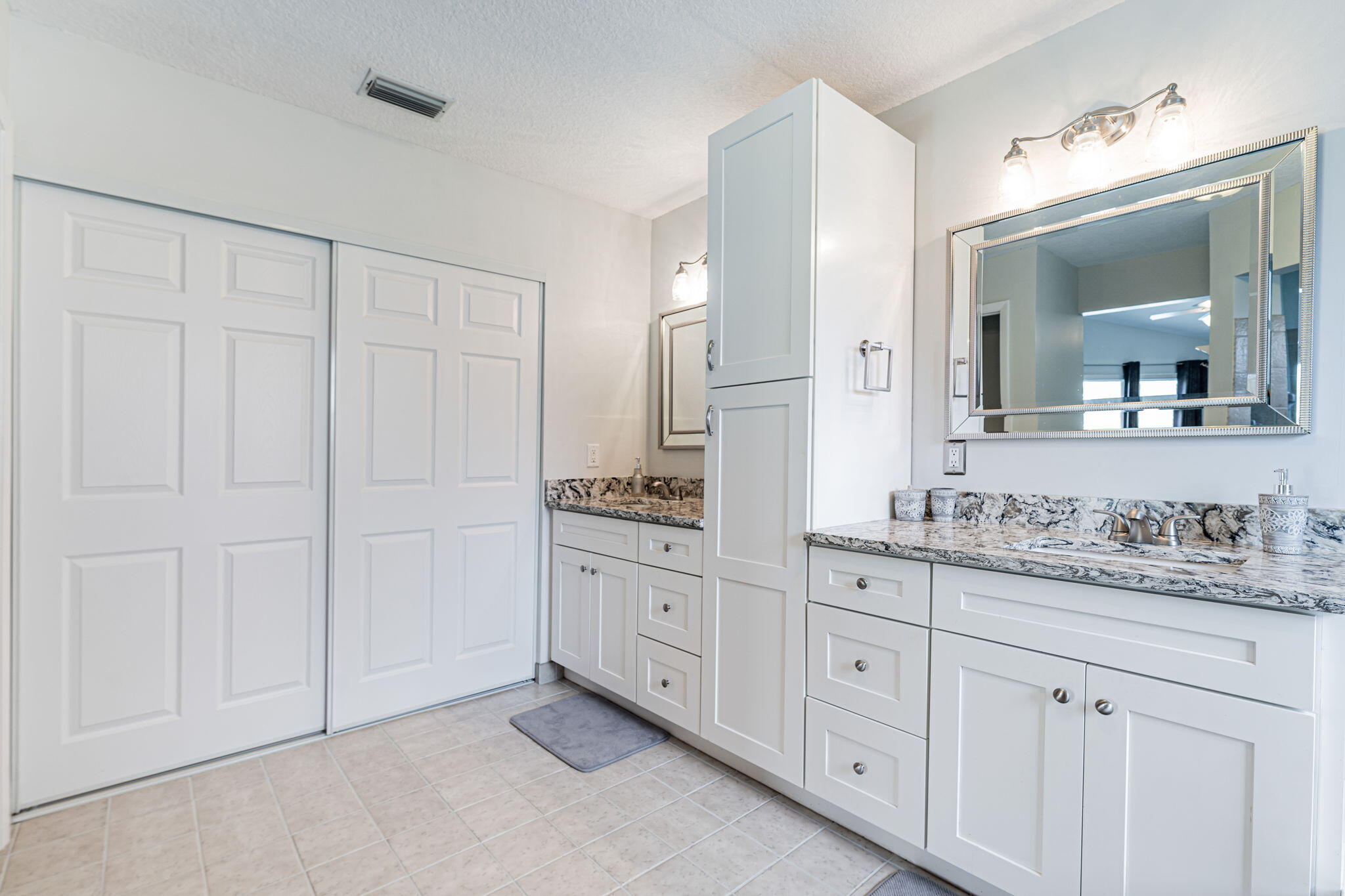 12715 Kingsway Road Wellington, FL 33414 - Photo 19 of 36 a spacious bathroom with a granite countertop sink and a mirror