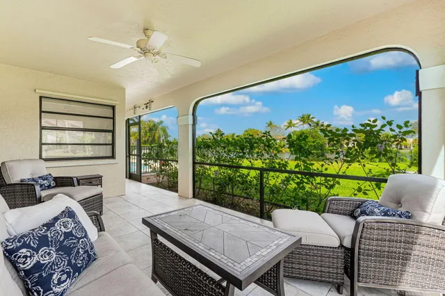 a living room with furniture plant and a large window